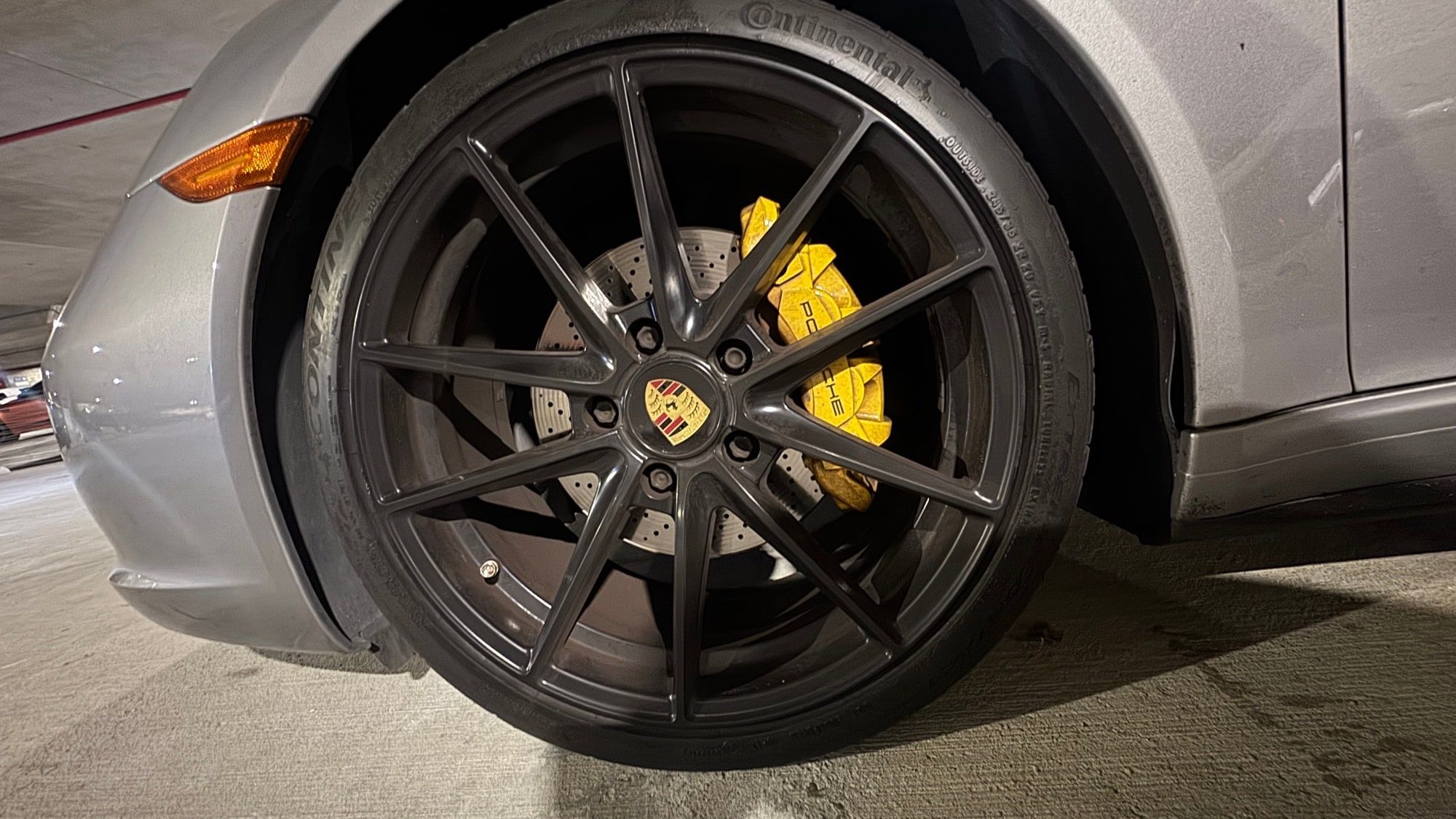 A Porsche wheel with yellow brake calipers
